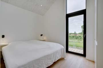 Schlafzimmer 2 - Doppelbett und Zugang zur Terrasse und Garten
