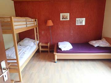 Schlafzimmer 1 im OG: 3-Bett-Zimmer (Einzel- und Etagenbett) mit fl. Wasser