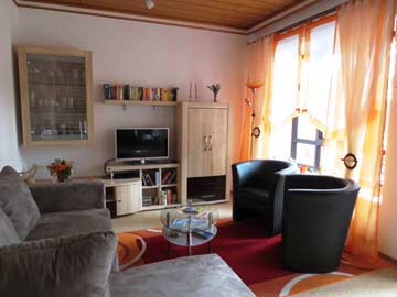 Wohnbereich mit Sofa, Sesseln und TV