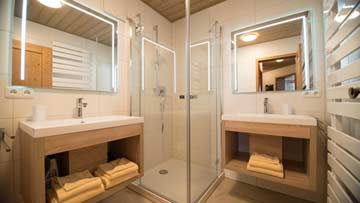 Badezimmer mit Dusche und Doppelwaschbecken