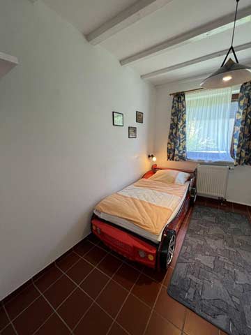 Schlafzimmer mit Etagenbett und kleinem Einzelbett im EG