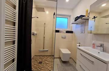 Badezimmer mit ebenerdiger Dusche und WC