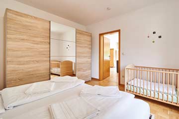Fewo 4: Schlafzimmer mit Doppelbett und Kinderbett