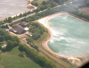 Luftaufnahme des Hofes mit Badesee