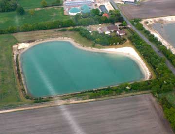 Luftaufnahme des Hofes mit Badesee