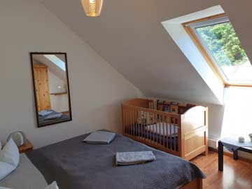 Schlafzimmer mit Doppelbett und Kinderbett