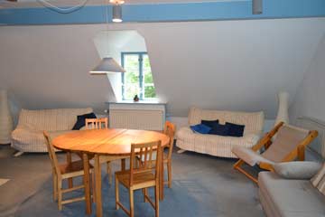 blauer Aufenthaltsraum mit Sesseln und Sofas