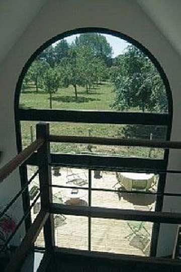 großes Panoramafenster mit Ausblick auf die Terrasse und die umstehenden Apfelbäume