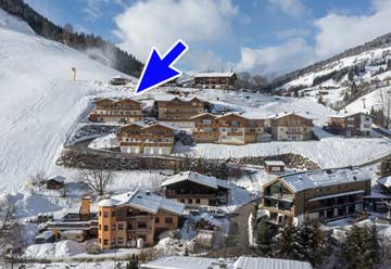 Ferienwohnung Saalbach an der Piste (die Piste links führt zu einer Skibushaltestelle, die Piste zur Talstation verläuft knapp oberhalb)