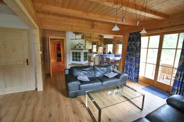 der Wohnraum mit Terrassenzugang, dahinter die offene Küche mit Esstisch; links der Zugang zur Sauna