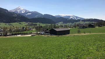 Rückansicht im Frühjahr mit Blick auf sie Skiberge der Salzburger Sportwelt