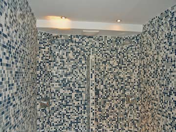 auf dem Foto durch das Mosaik etwas schwer zu erkennen: die Raindance-Dusche im Wellnessbereich (links) mit Wasserschwalldusche (rechts)