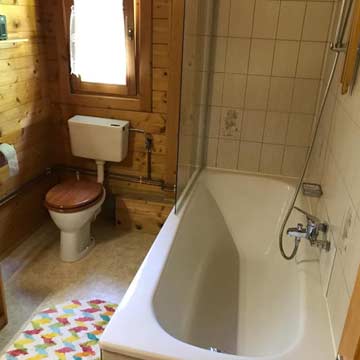 Badezimmer mit Badewanne und WC