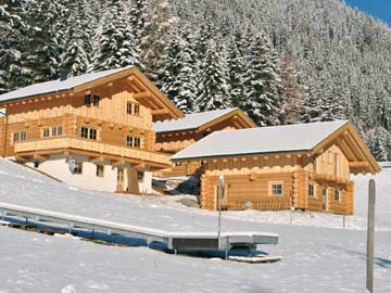 Ferienhaus Hochoetz (rechts) im November beim ersten Schneefall, das Förderband des Skikindergartens (Bildvordergrund) schaut noch aus dem Schnee heraus.