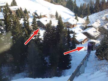 der Schräglift in die Dorfmitte (rechter Pfeil) und das Haus (linker Pfeil). Der nächste Skilift ist deutlich näher (durch die Bäume aber auf dem Foto verdeckt)