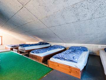 das einfache Matratzenlager unter dem Dach
