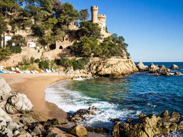 Playa de Fenals mit dem Schloss Sant Joan